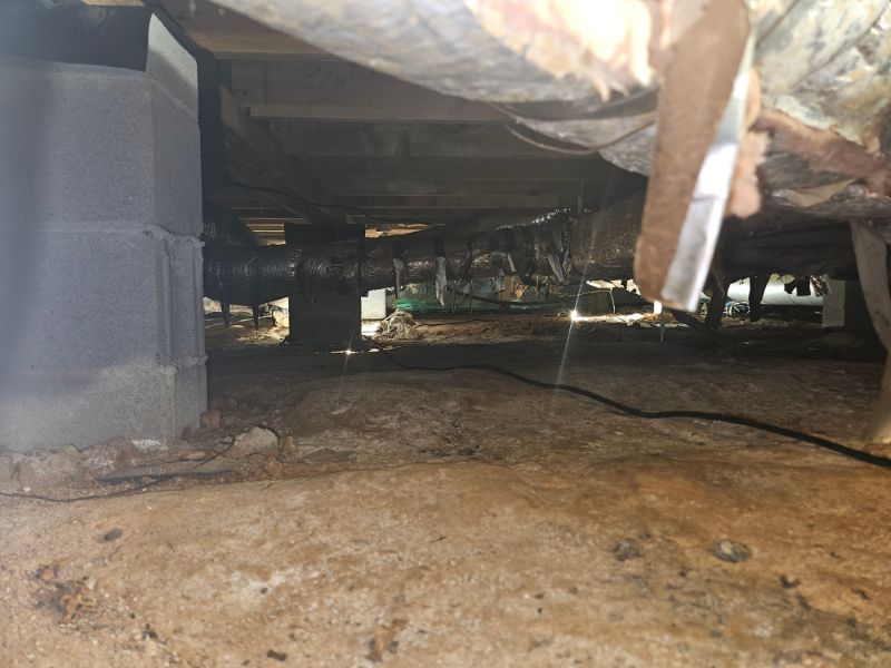 Crawl space with exposed soil, block piers and sagging insulation