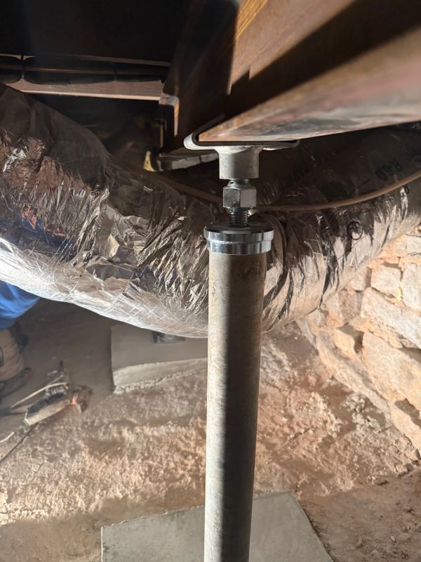 Steel support post with an adjustable top plate supporting a floor beam