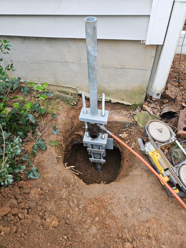 Helical pier with a steel underpinning bracket installed at a home's footing